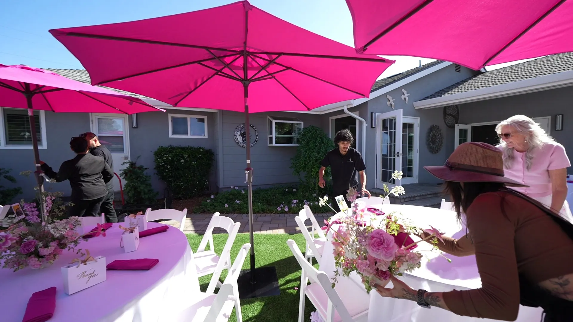 Backyard tables with pink umbrellas and fresh florals at a South San Francisco catered party