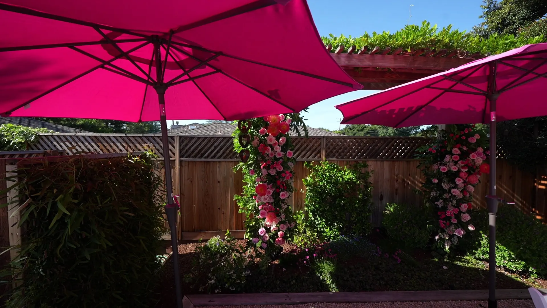 Shaded patio with market umbrellas and a rose-covered arch at a San Francisco catered party
