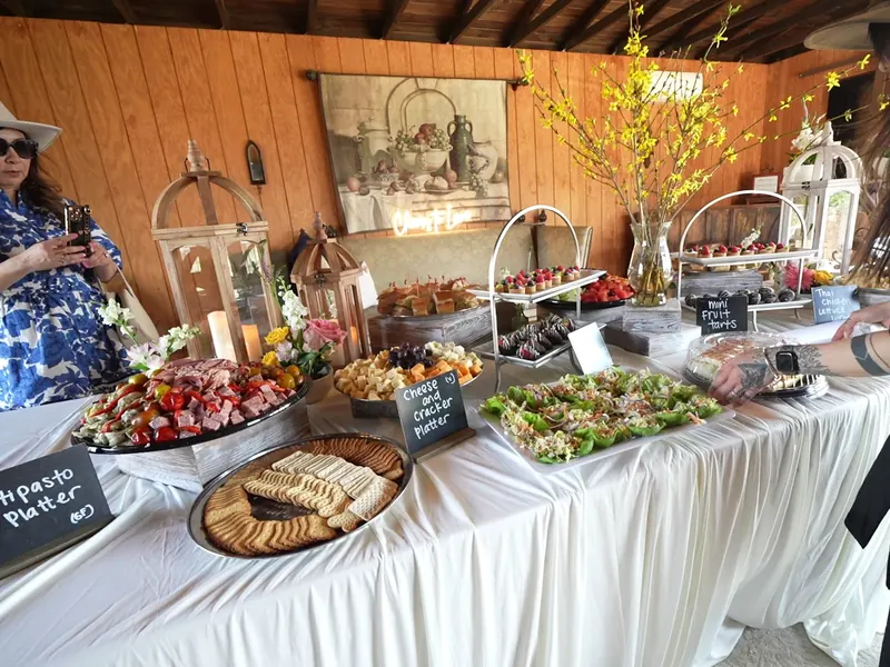 Antipasto, cheese and cracker platters on a draped buffet table at a Brisbane event