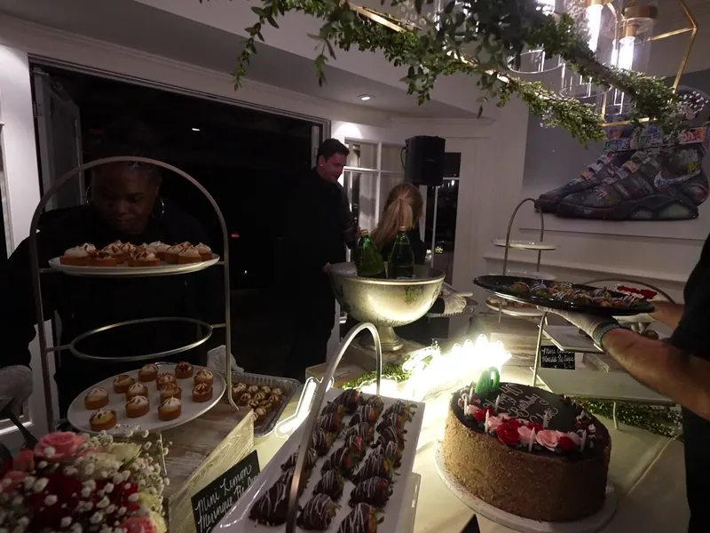 Tiered dessert display with chocolate-dipped strawberries and a celebration cake at a San Francisco party