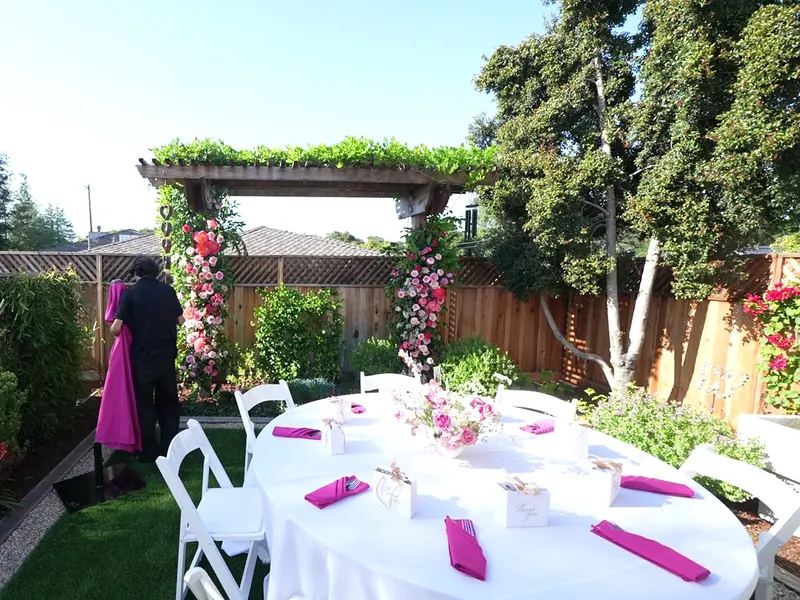 Floral arch and a set round table in a backyard catered lunch in San Francisco