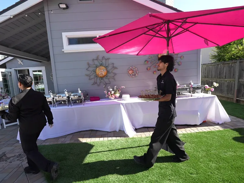 Uniformed attendants running a chafing-dish buffet on a patio at a Brisbane catered party