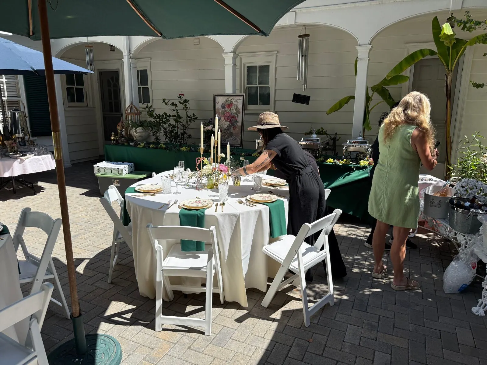 Courtyard rounds finished in emerald cloth with upgraded rental chairs, stemware and place settings — elevated rentals from SF catering