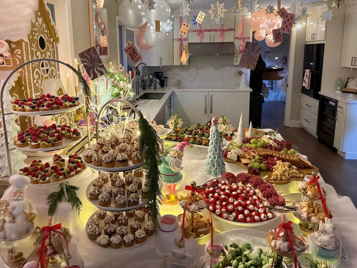 Fully styled sweets-and-starters tablescape with tiered tarts, frosted cupcakes, cured meats and pastel balloons overhead — tablescape styling from SF and Daly City catering