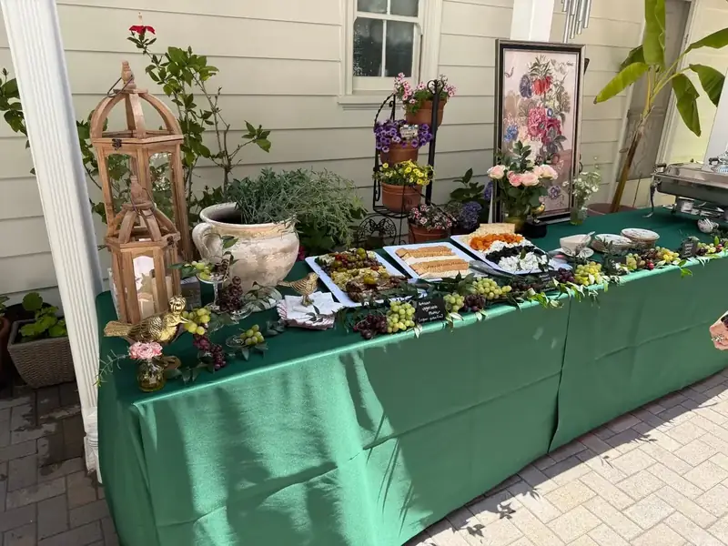 SF Catering Company private-event spread with colorful hors d’oeuvres, cheese boards, floral arrangements, and lush tabletop styling.
